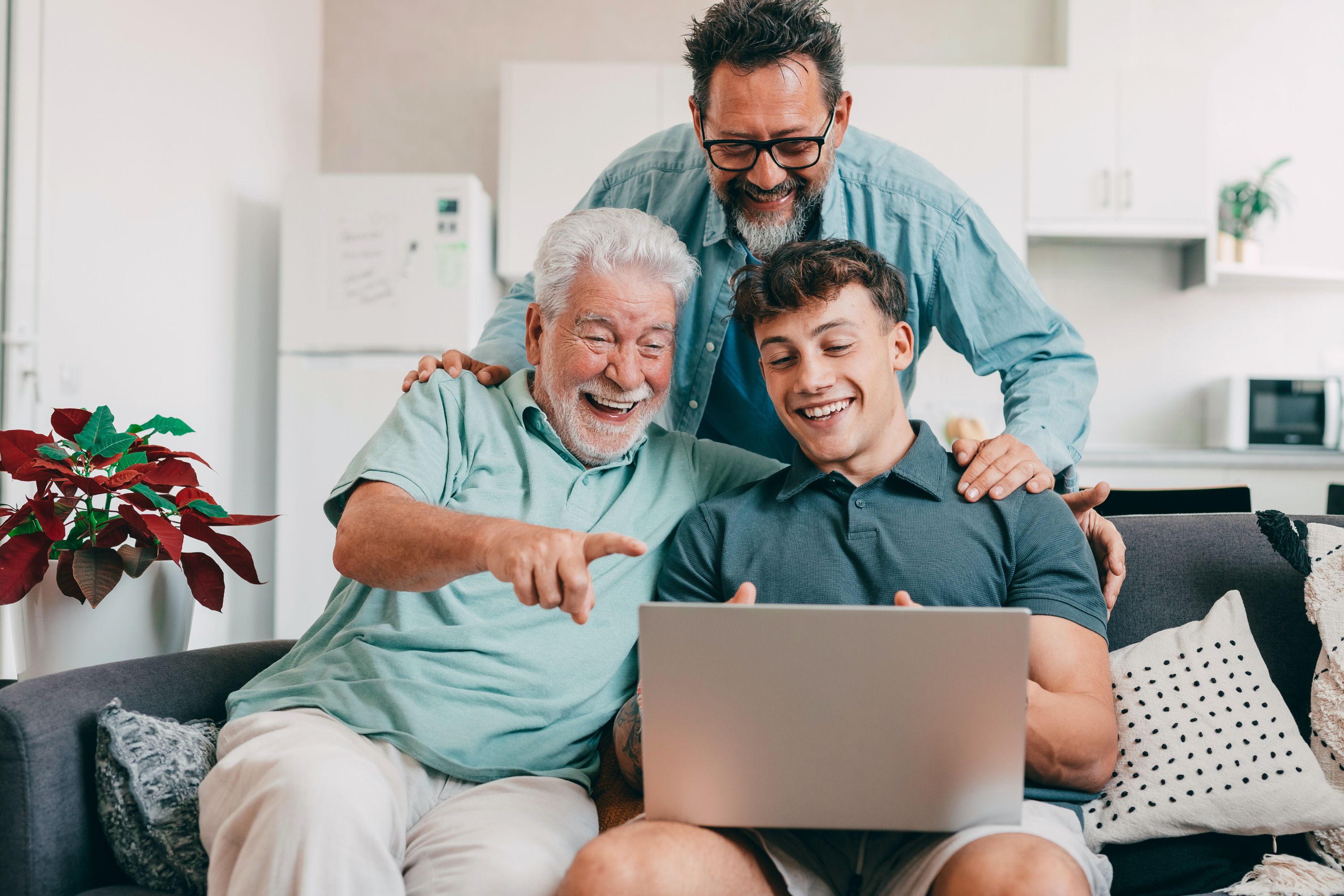 Three generations of men looking at laptop