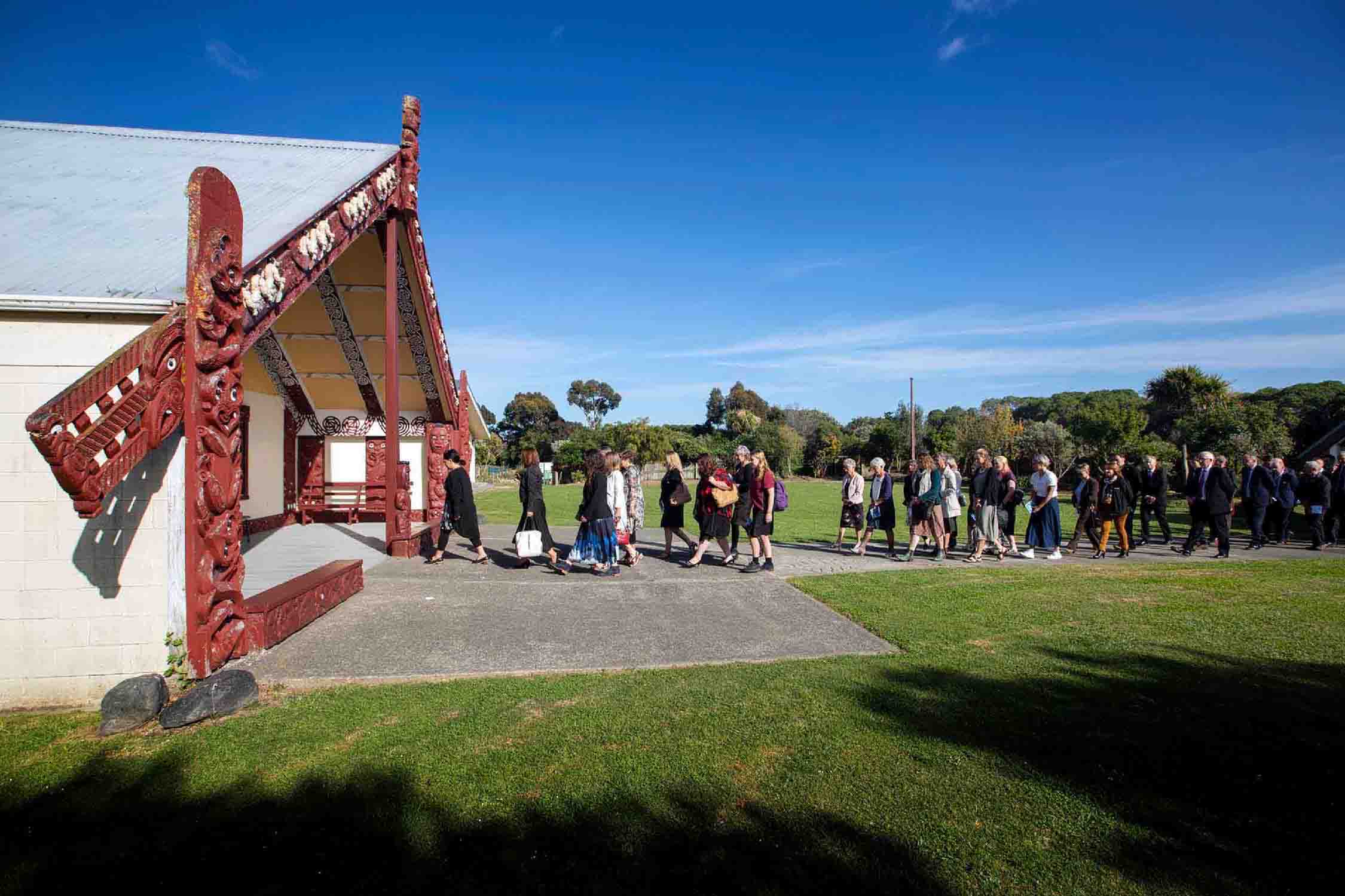 Line of people waiting to walk inside a house