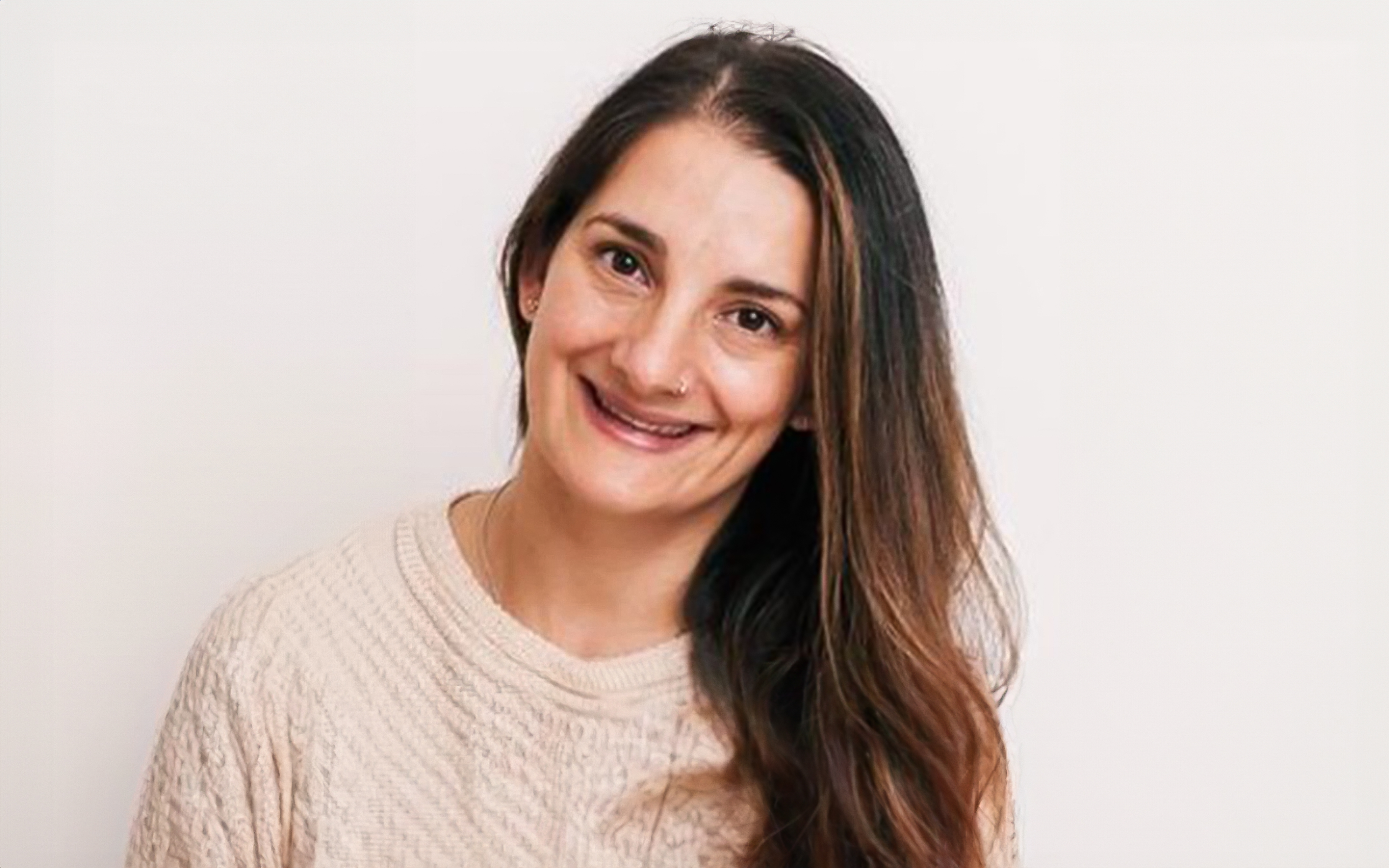 Photograph of Yanina Amatore wearing a cream jumper smiling into the camera.