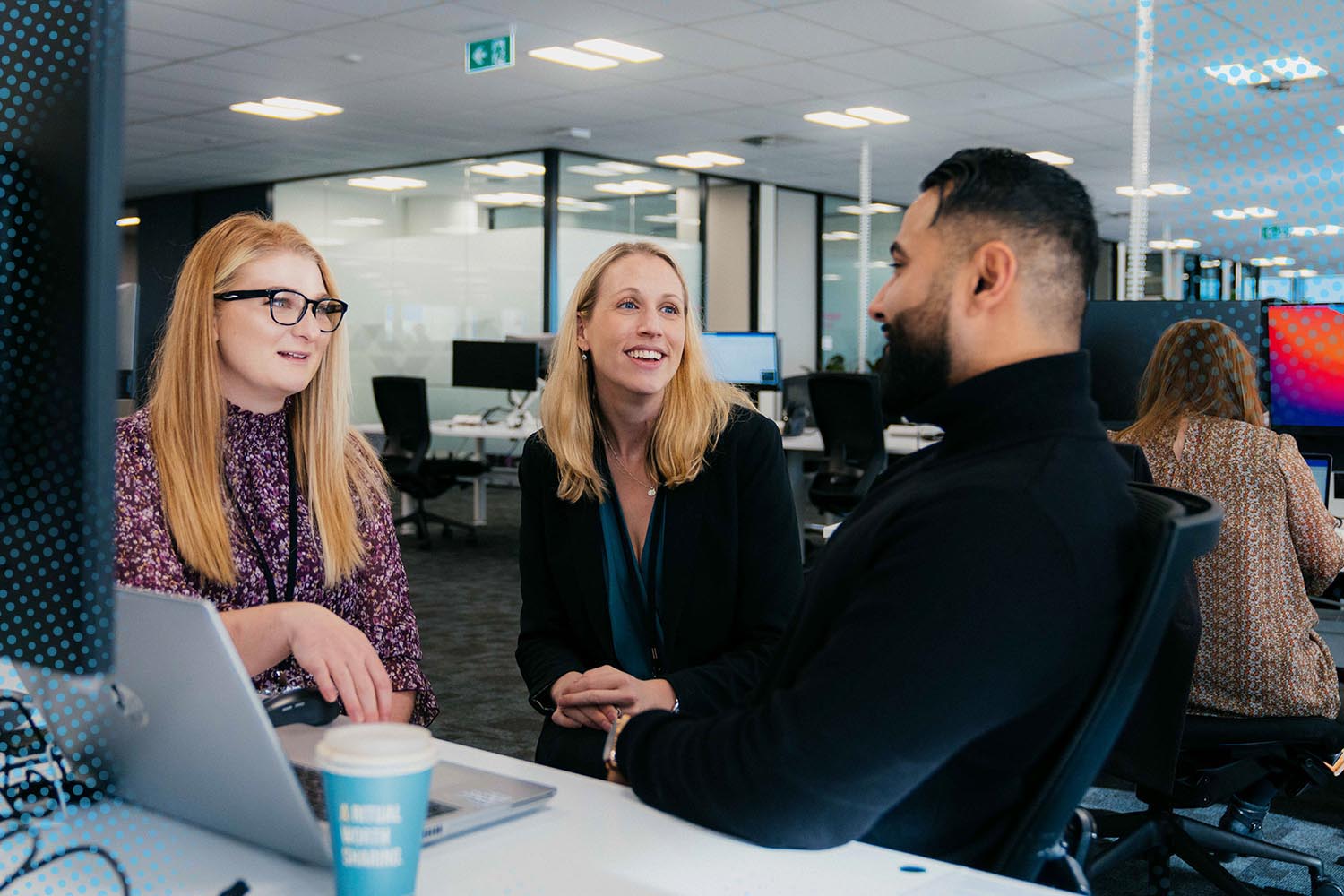 Datacom employees having a discussion in the Auckland Tahi office