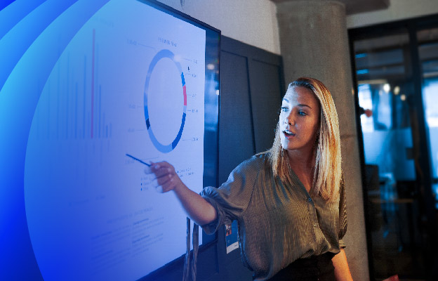 A female professional presenting data on a board