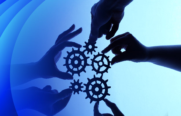 Hands holding gears against the sky