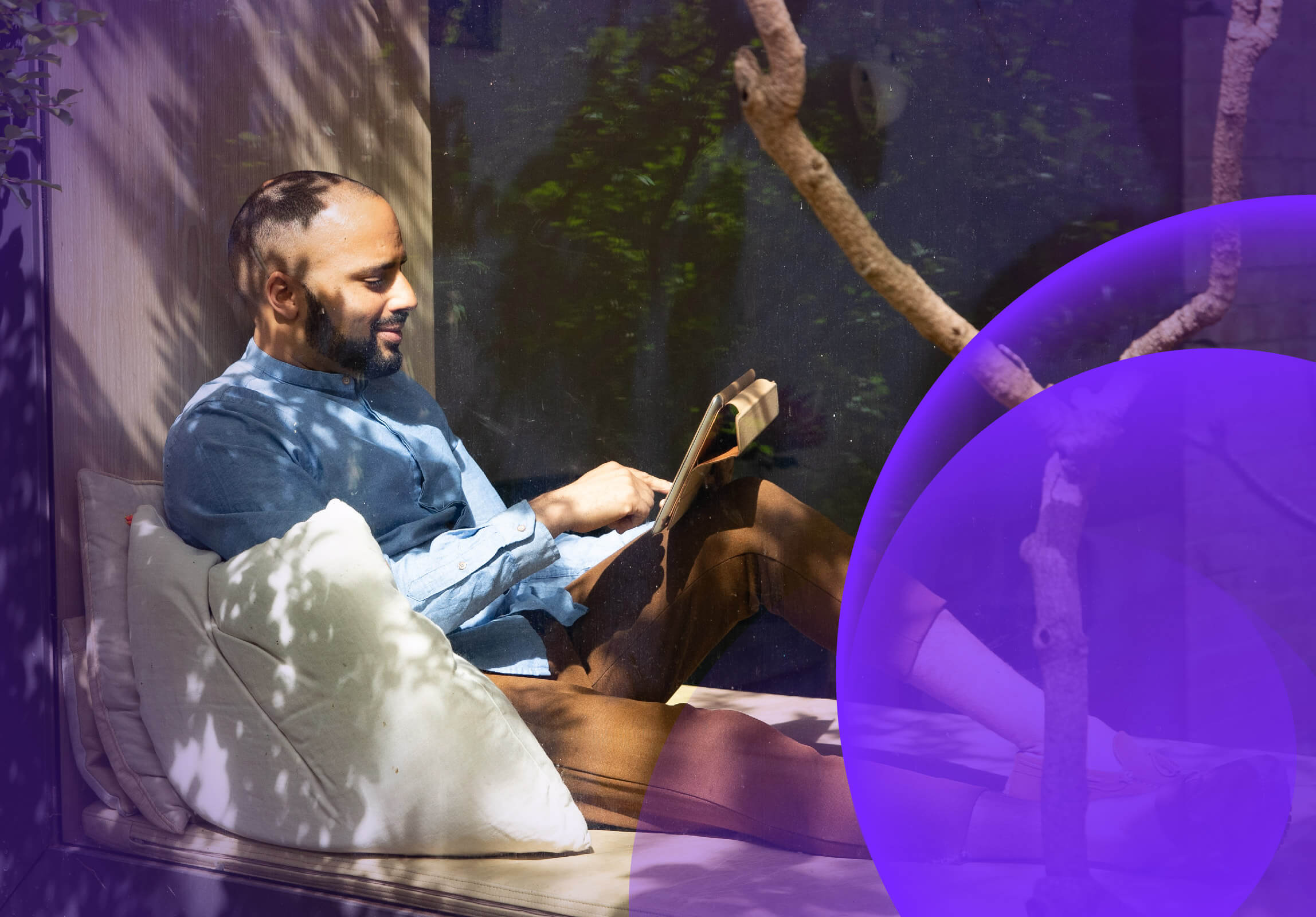 A man relaxing and using a tablet in an outdoor area
