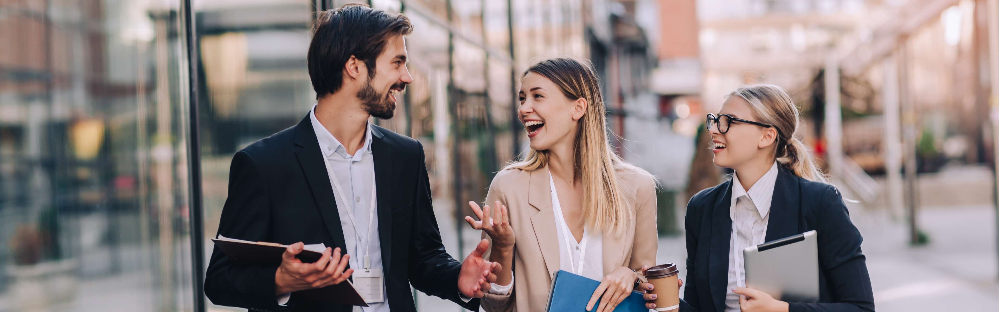 A group of people looking at eachother and smiling while walking